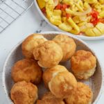 fried dumplings sitting in bowl with ackee in a bowl to the right