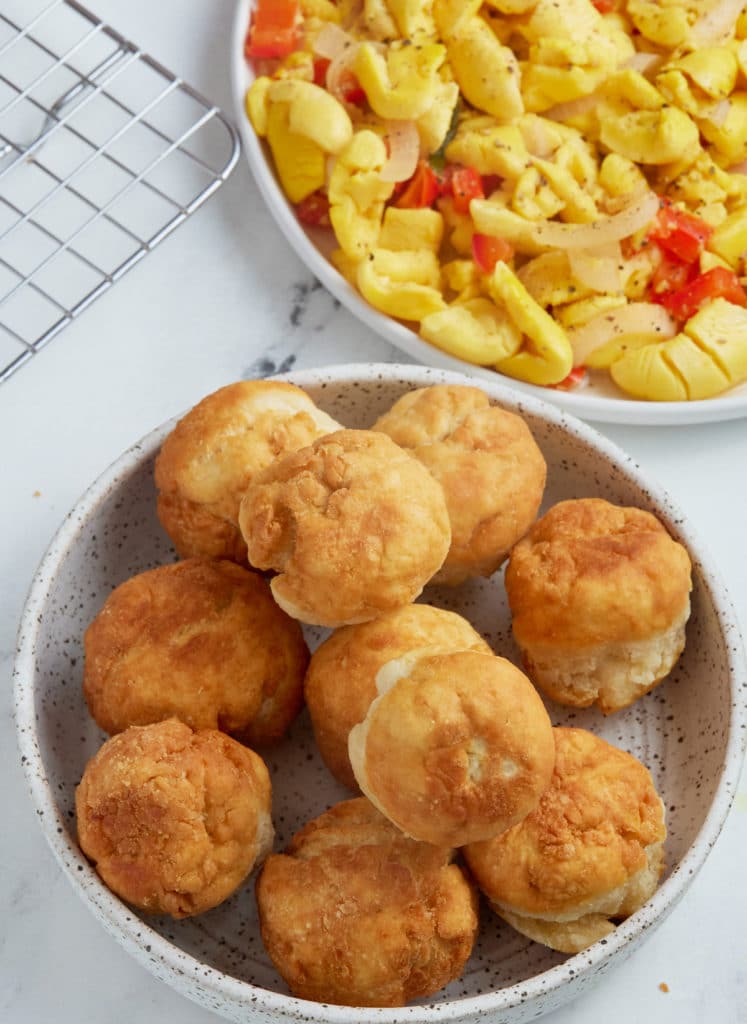 fried dumplings sitting in bowl with ackee in a bowl to the right