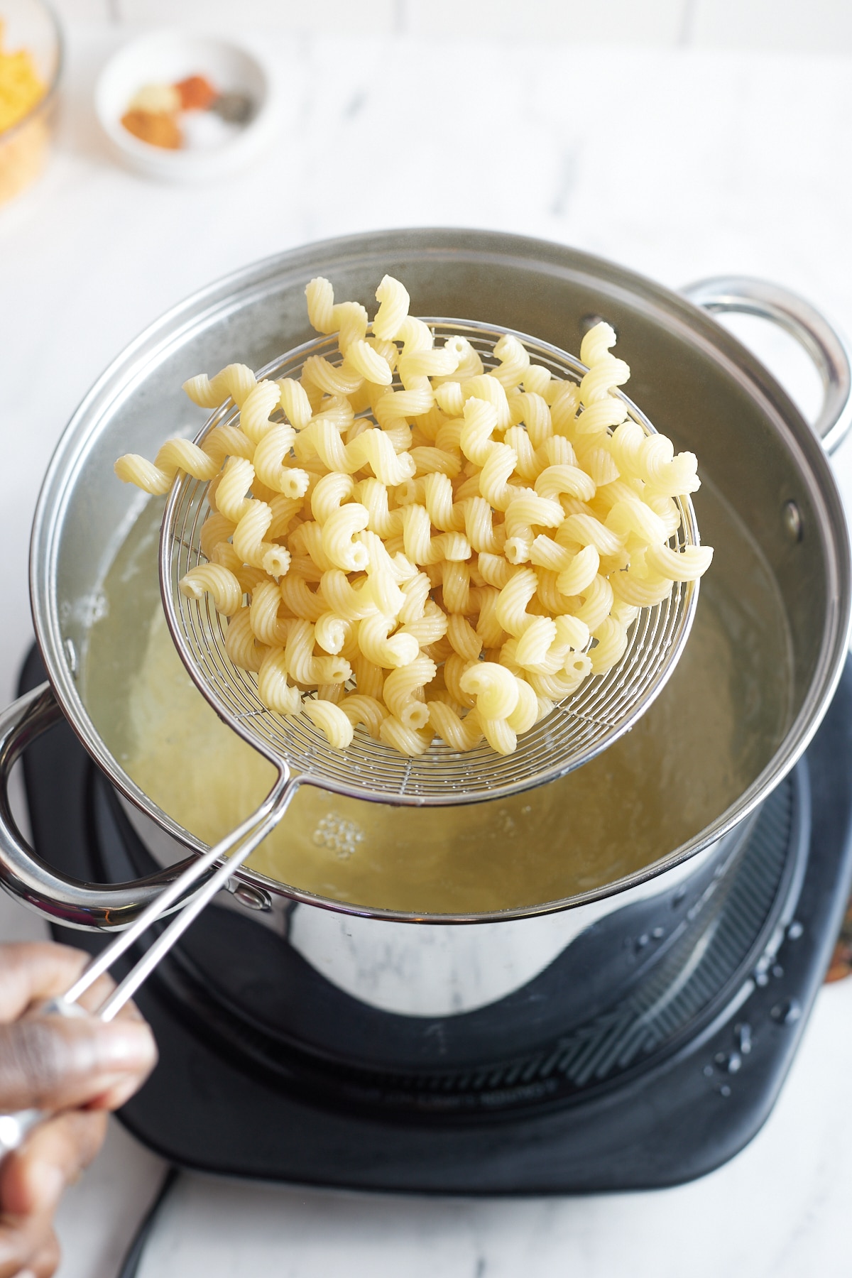 Draining the cooked macaroni.
