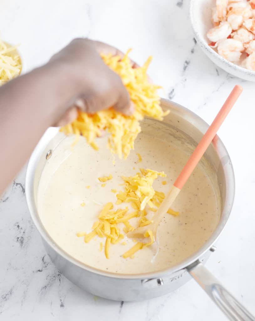 cheese being added to cheese sauce