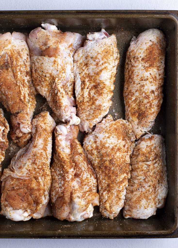 Seasoned turkey wings in a roasting pan.