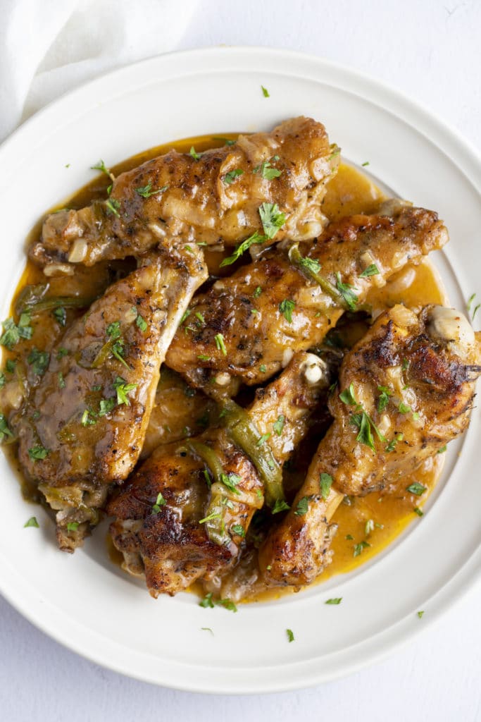 Smothered turkey wings garnished with fresh herbs.
