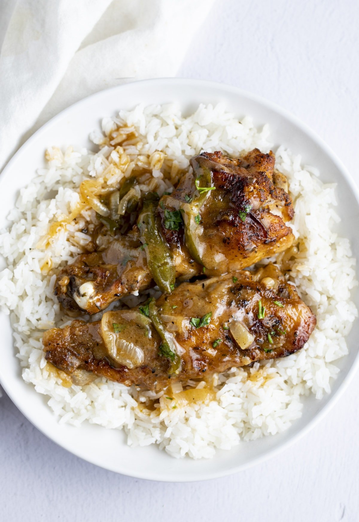 Smothered turkey wings and rice served on a white plate.