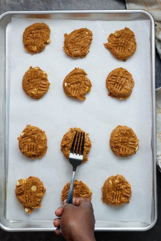 A fork pressing the cookies flat.