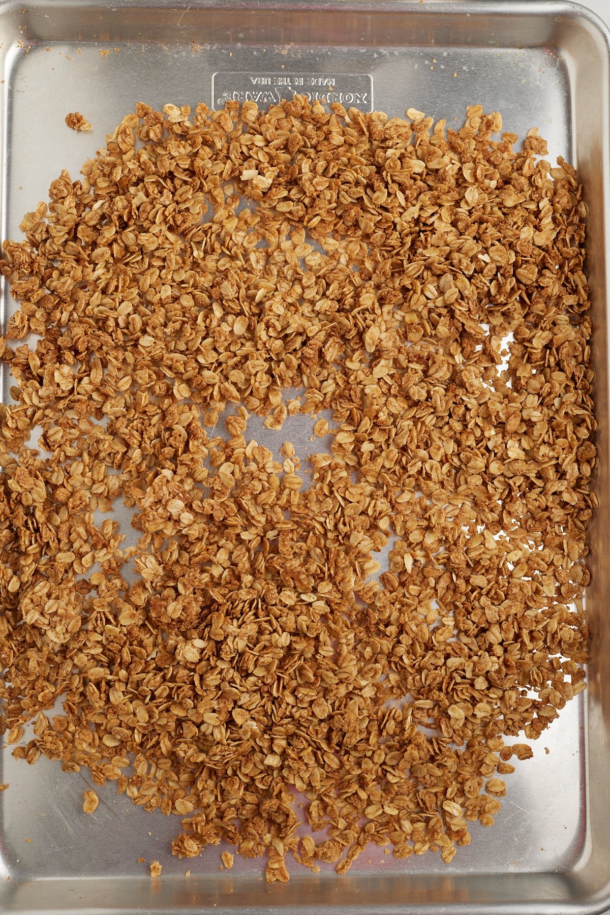 Granola spread out on a baking sheet to cool.