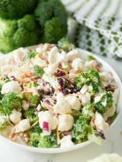 Broccoli and cauliflower salad in a white bowl.