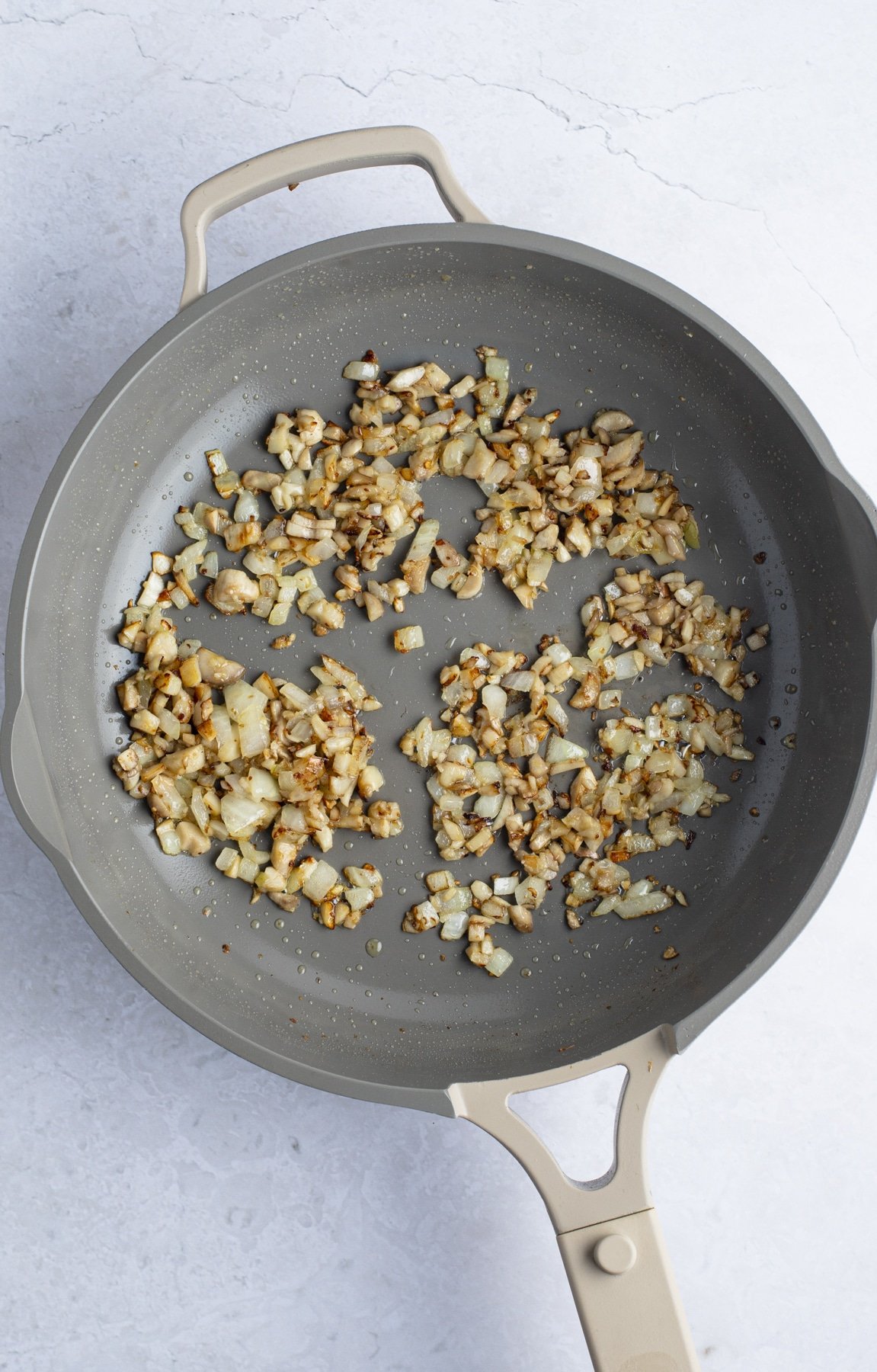 Onions, garlic and mushroom stems in a skillet.