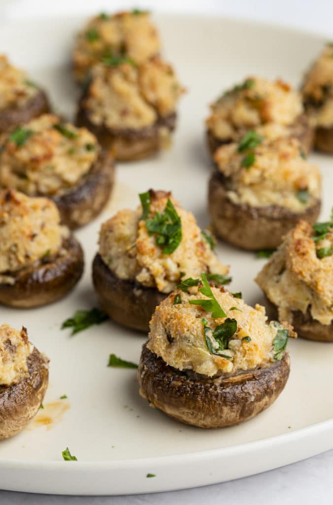 Baked cream cheese stuffed mushrooms garnished with fresh parsley.