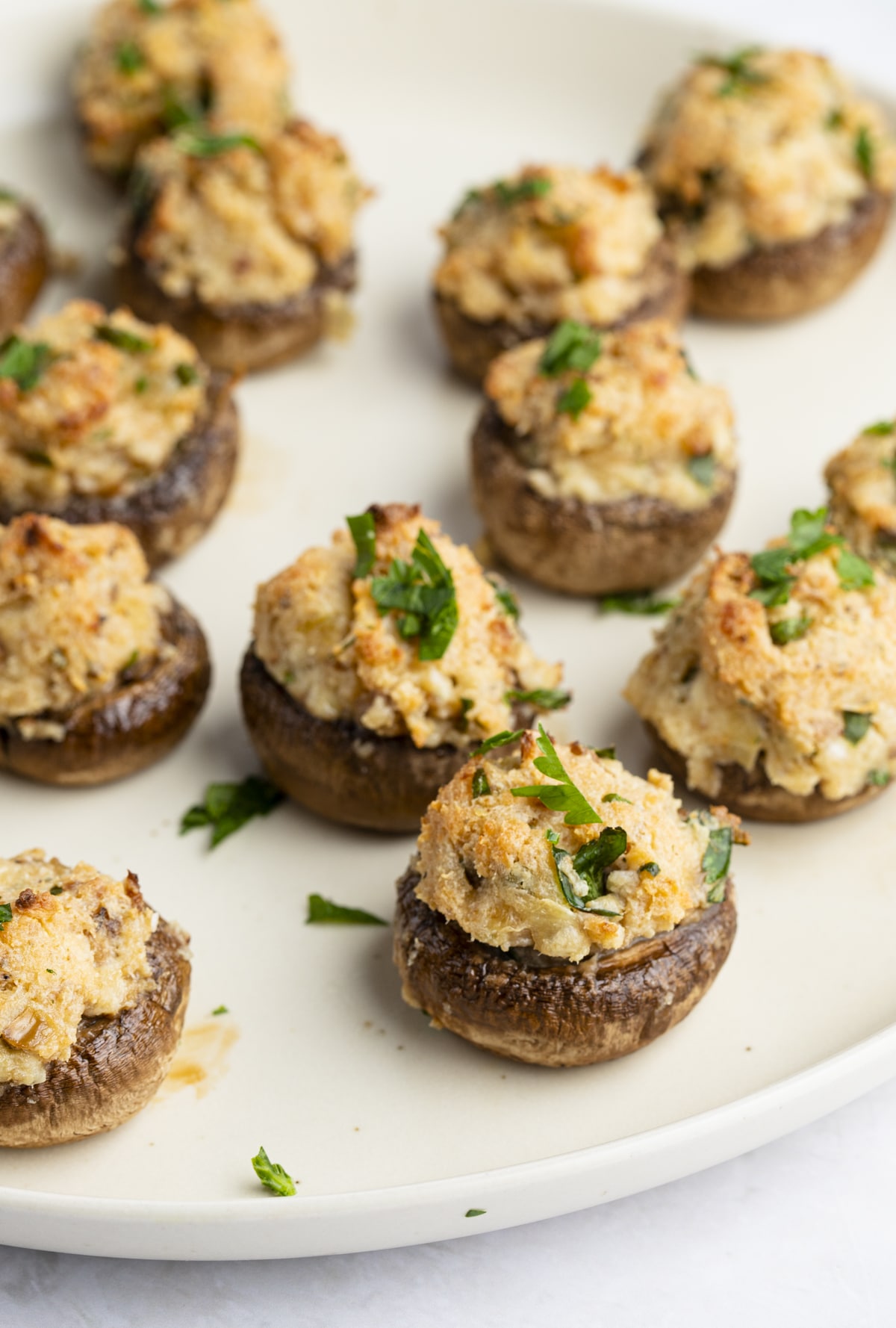 Cream cheese stuffed mushrooms served on a white plate.