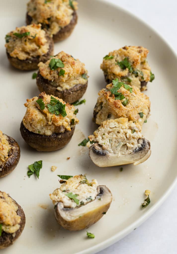 One of the stuffed mushrooms cut in half on a plate.