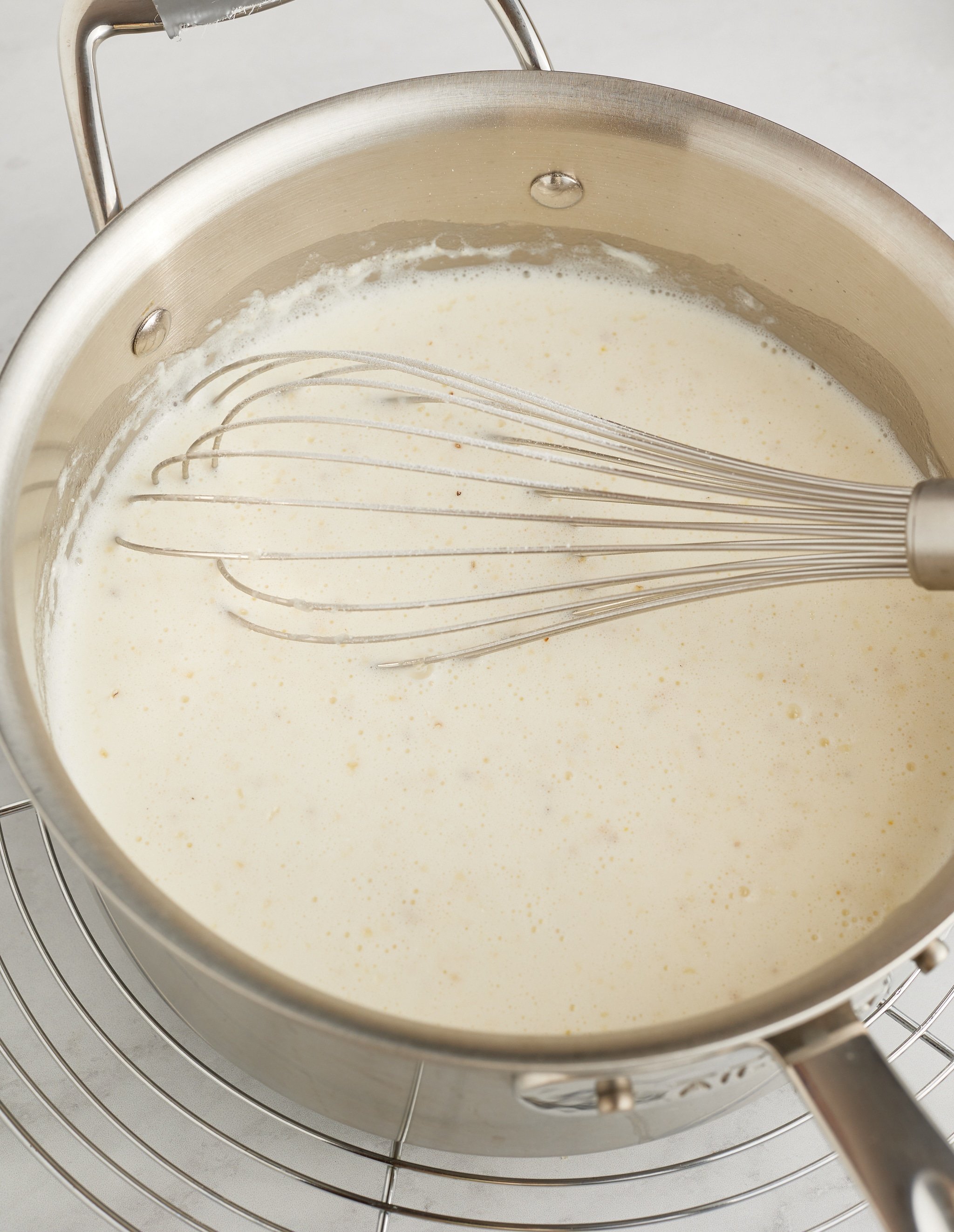 grits being cooked with whisk sticking in it