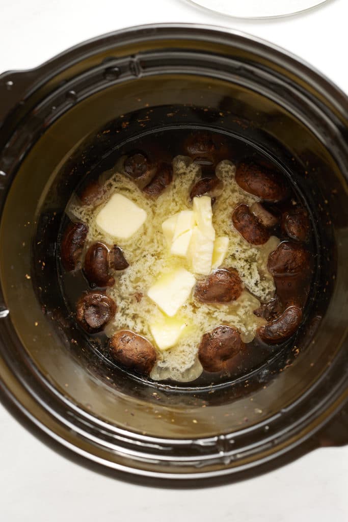 mushrooms in liquid and butter in slow cooker