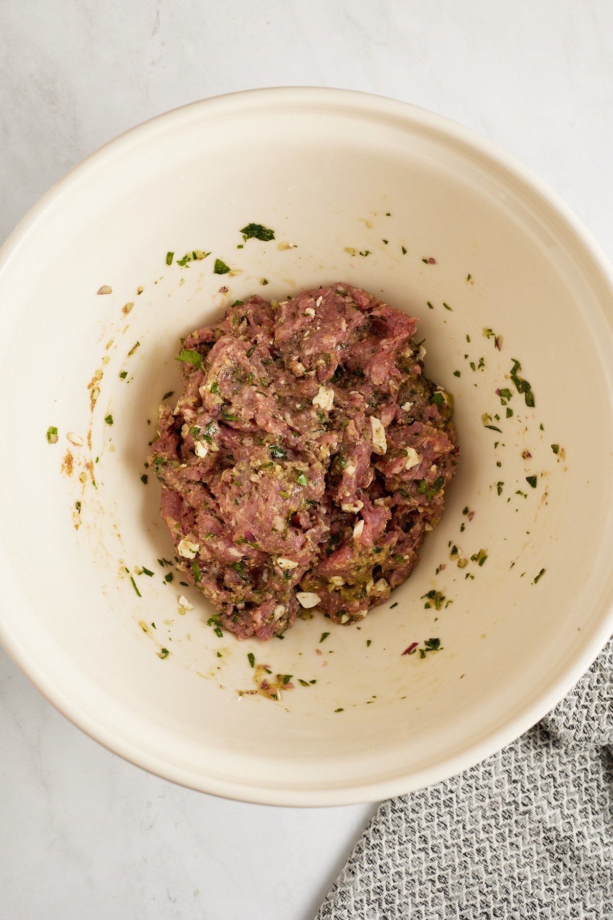 ingredients for lamb meatballs combined in bowl