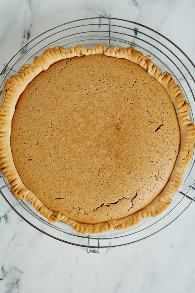 A baked pinto bean pie on a cooling rack.