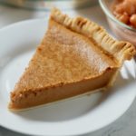 A slice of pinto bean pie served on a white plate.