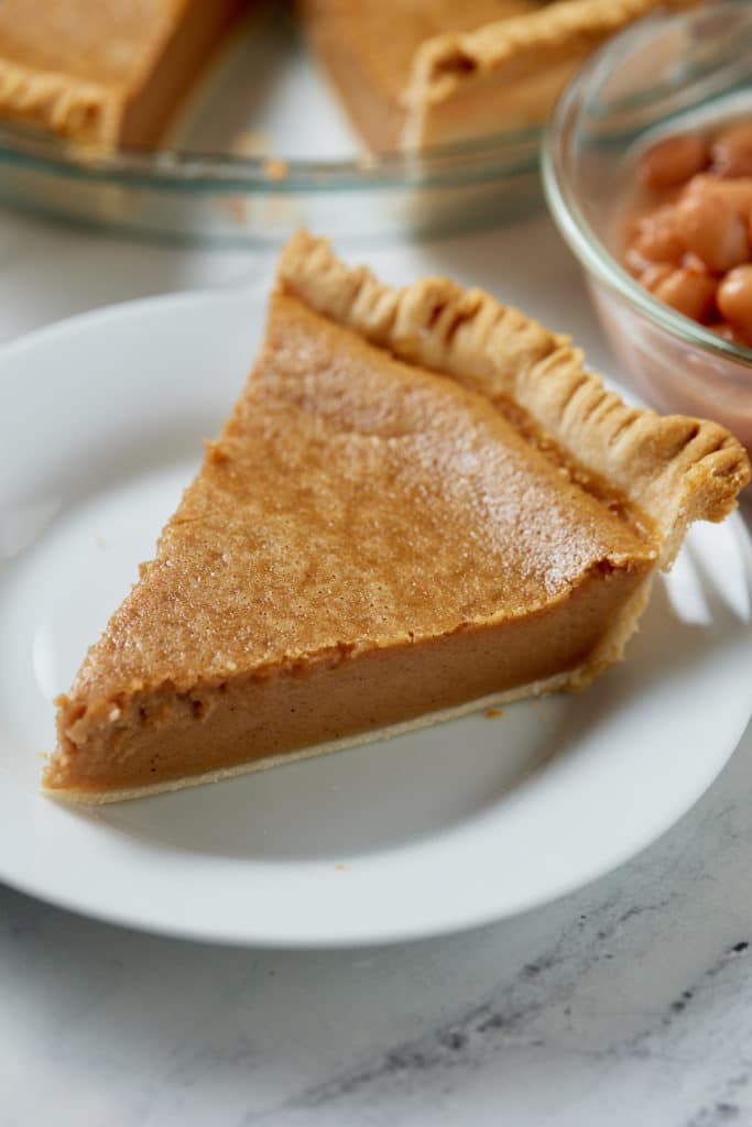 A slice of pinto bean pie served on a white plate.