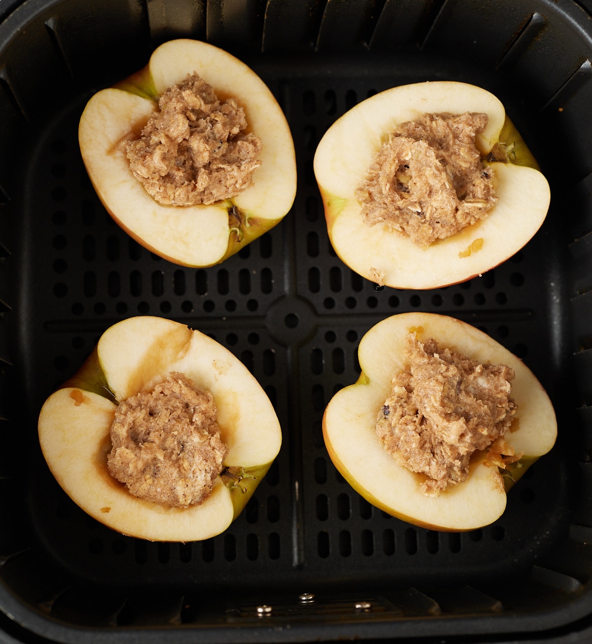 The apples with filling placed into the air fryer basket.