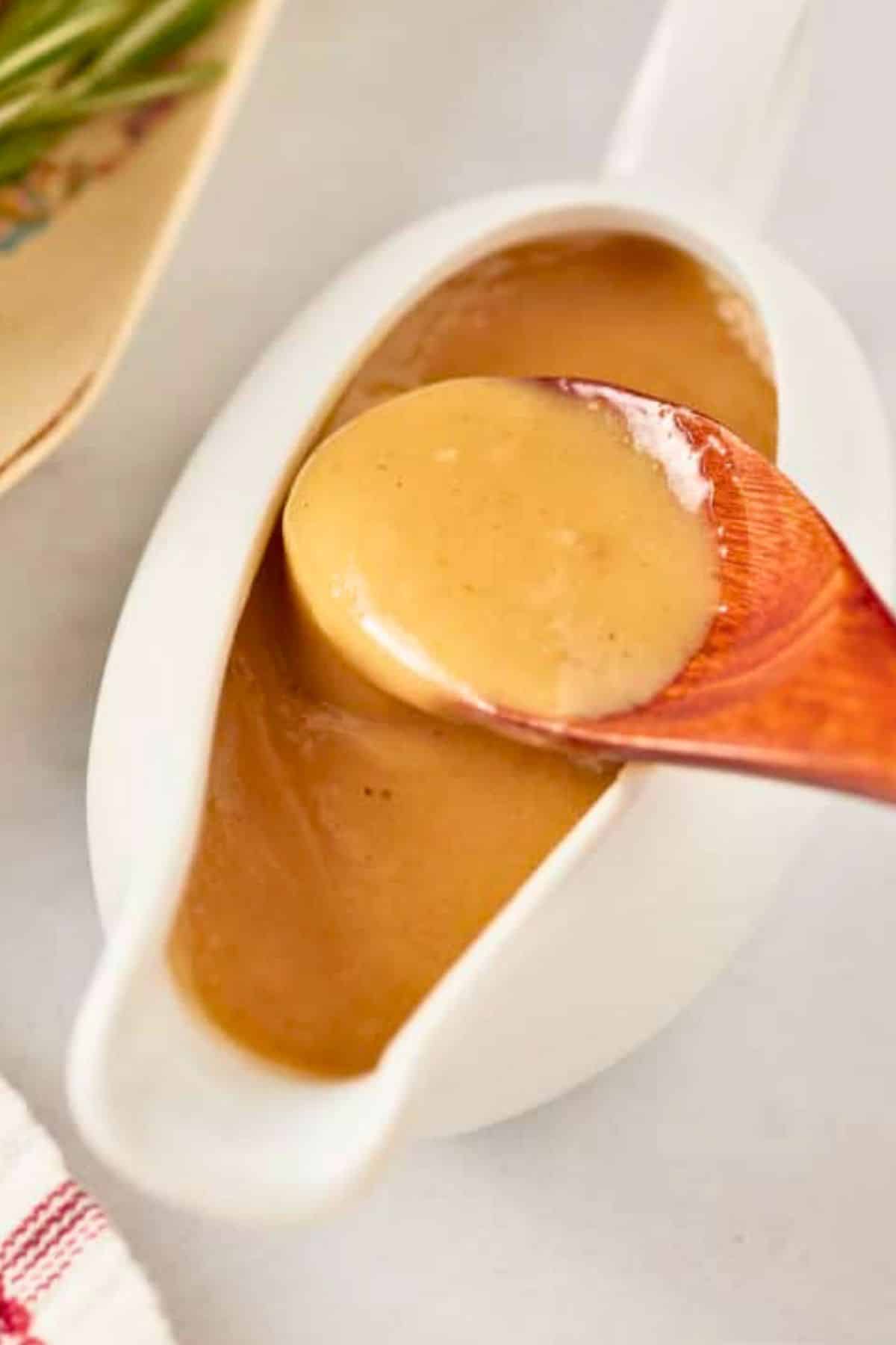 gravy in a gravy boat woth spoon picking it up