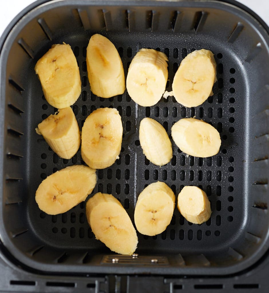 Plantain slices in the air fryer basket.