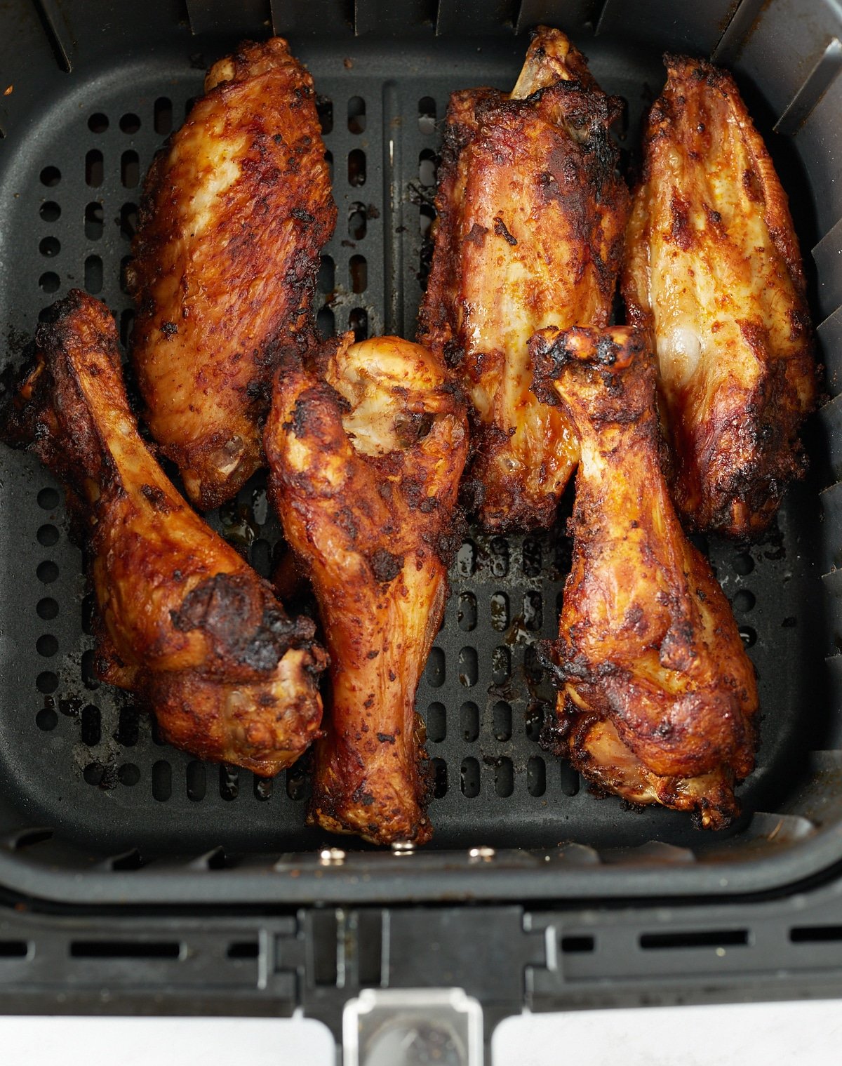 The wings in the air fryer basket after being cooked.