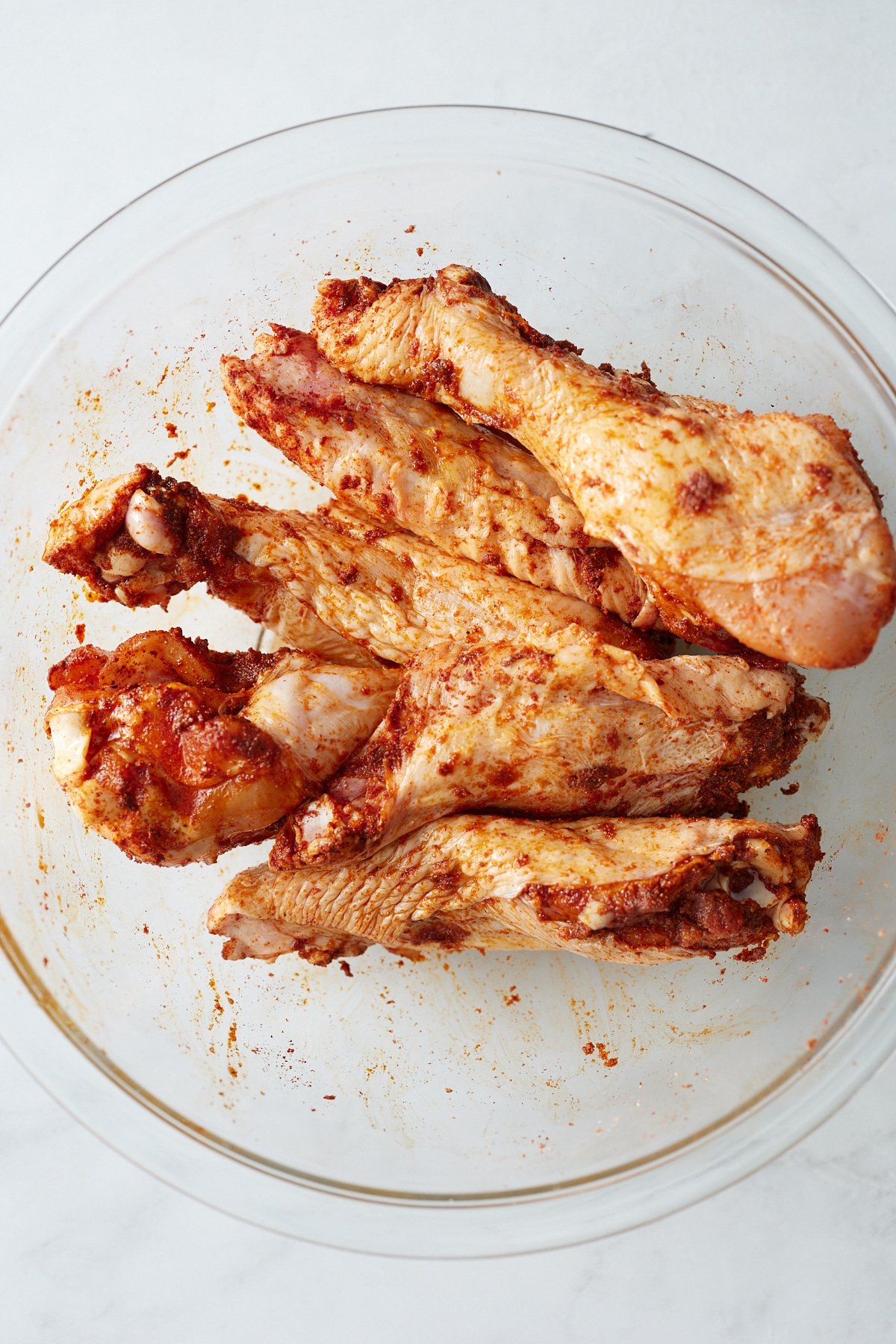 Turkey wings in a bowl rubbed with the seasonings.