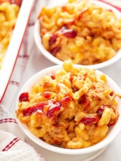 Two bowls of mac and cheese topped with BBQ sauce.