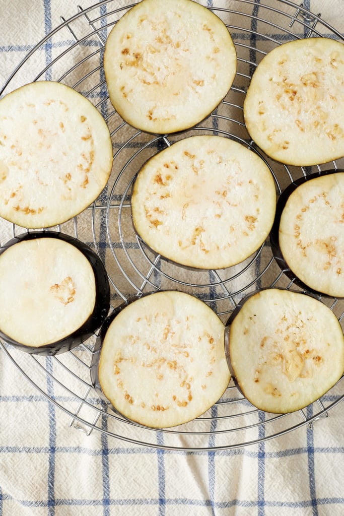 Slices of eggplant on a wire rack.