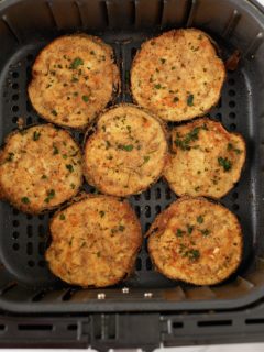 Cooked crispy eggplant in an air fryer basket.