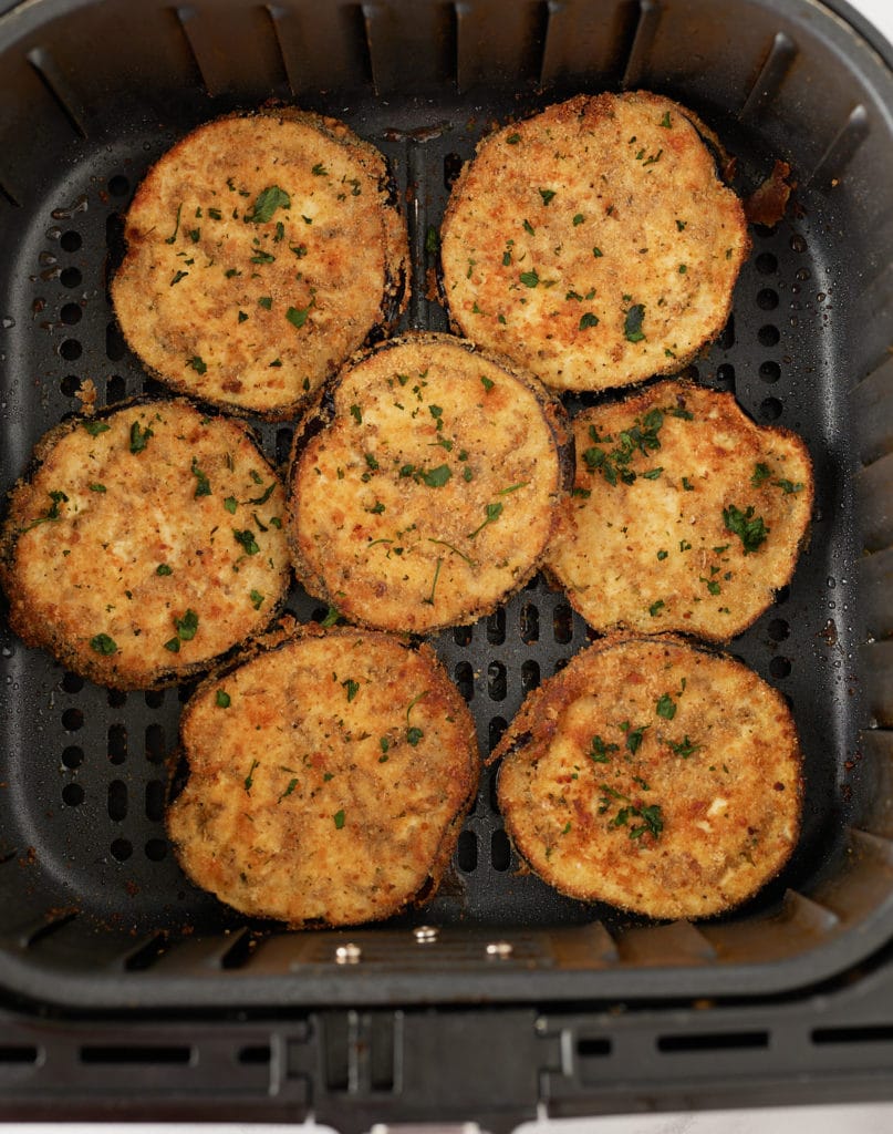 Cooked crispy eggplant in an air fryer basket.