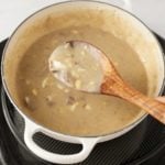 Stirring the giblet gravy with a spoon.