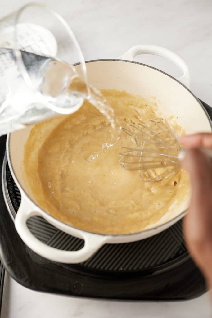 Water being whisked into the pan.