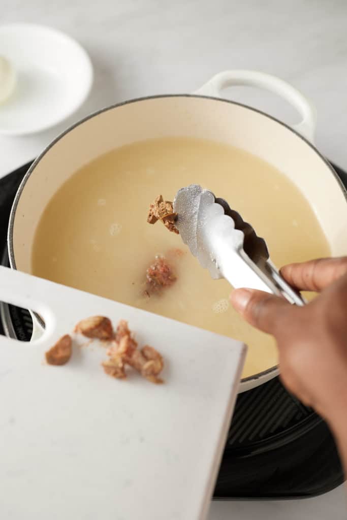 Giblets being added back to the pan.