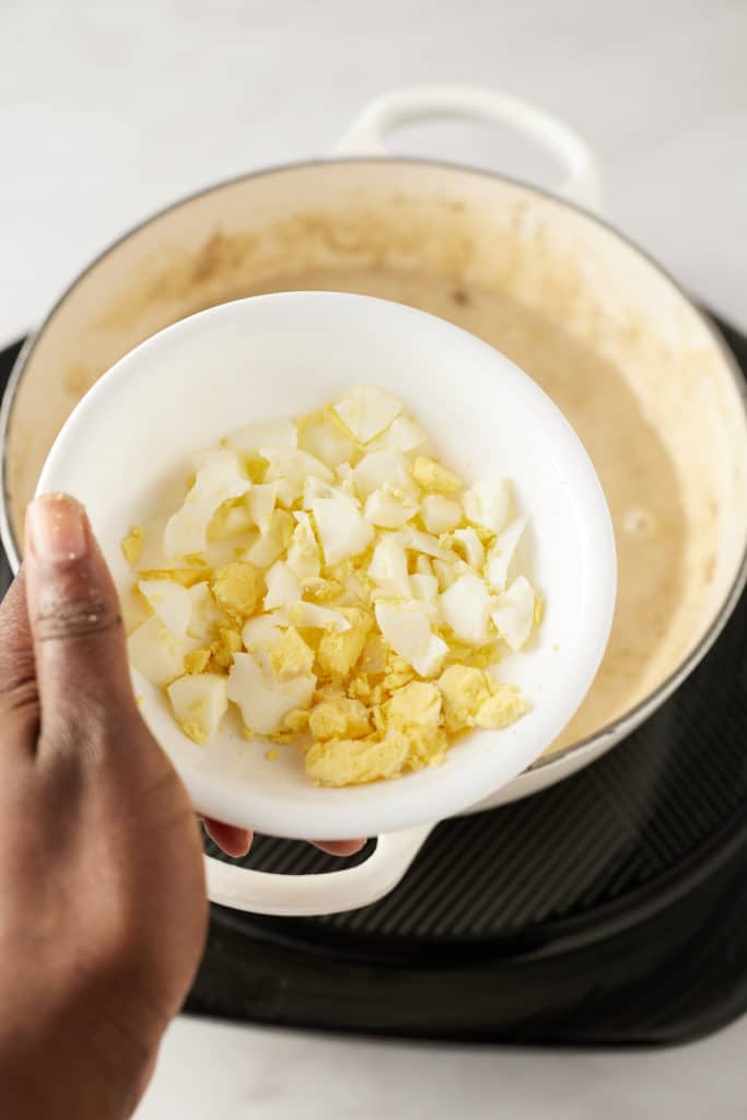 Hard boiled egg being added to the gravy.