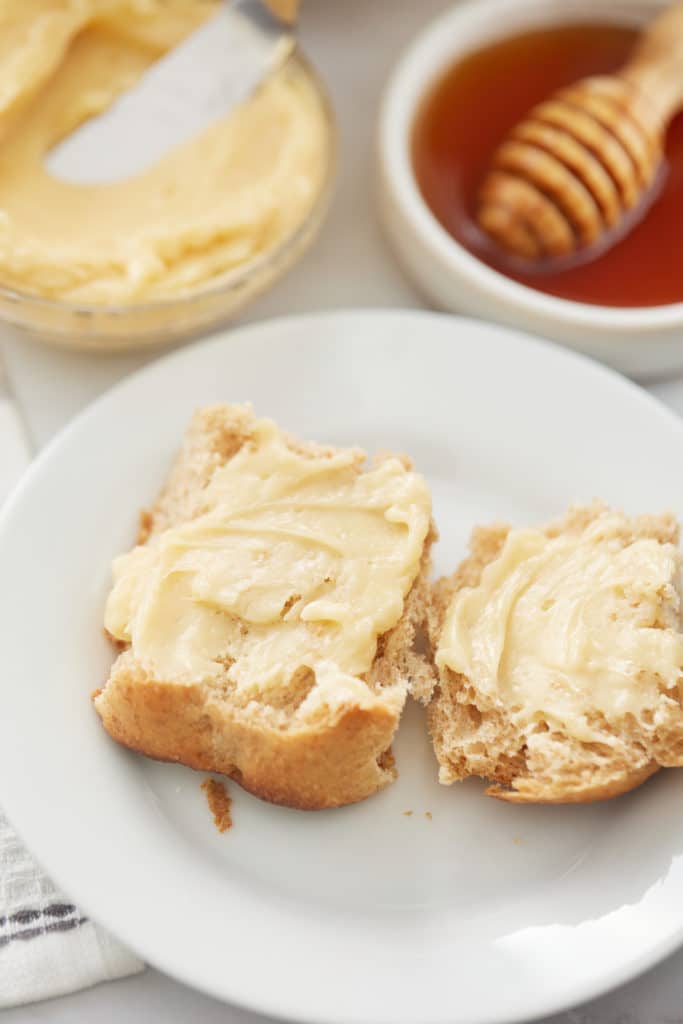 honey butter on bread with butter and honey in the background