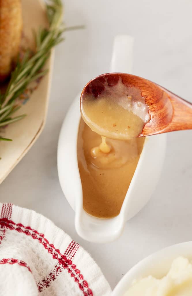 Spooning the dripping gravy into a gravy boat.