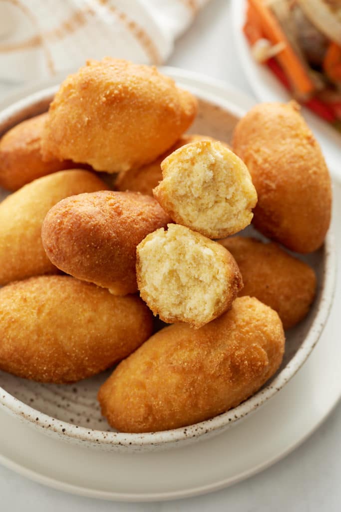 fried festival dough in plate with one broken to see inside