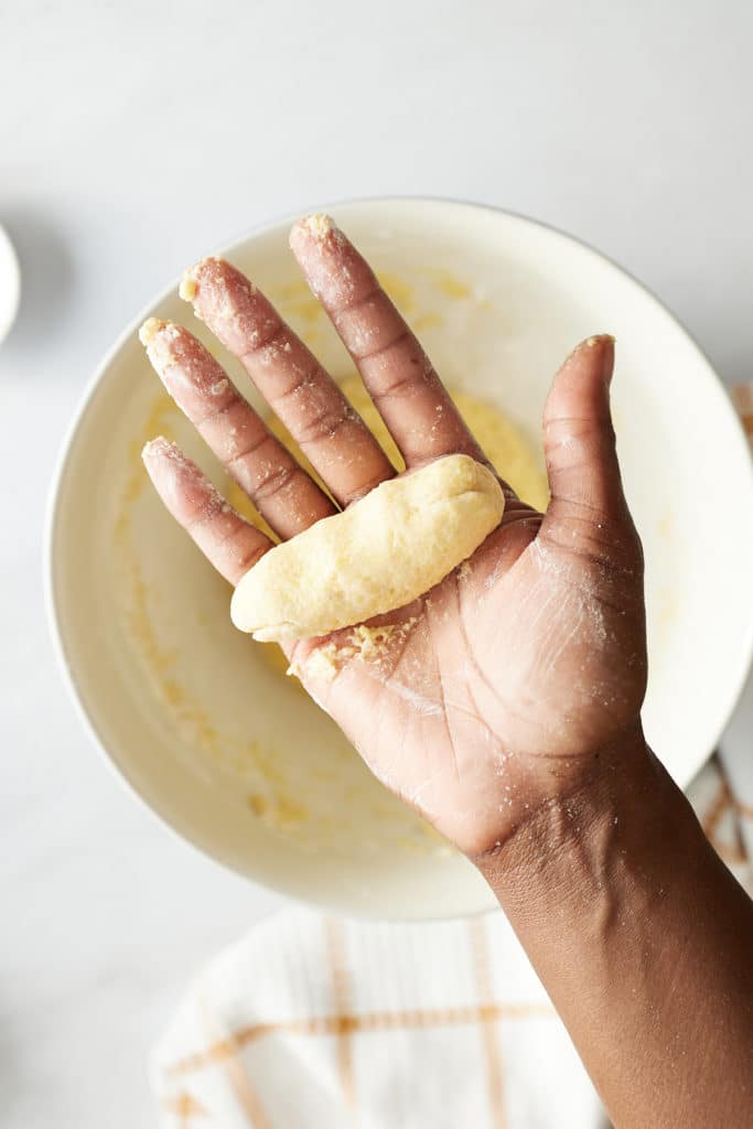 festival dough rolled into long oval shape in hand