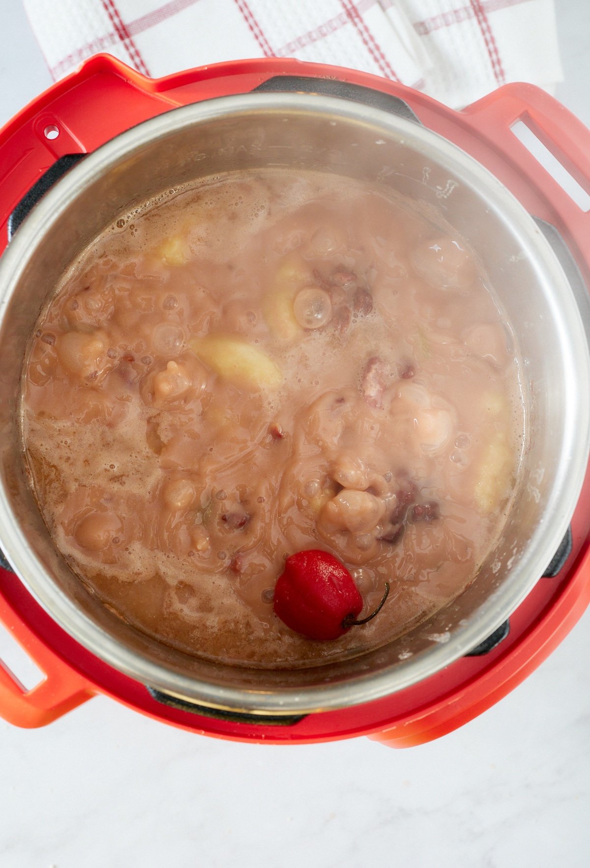 stew cooking with scotch bonnet pepper and spinners added