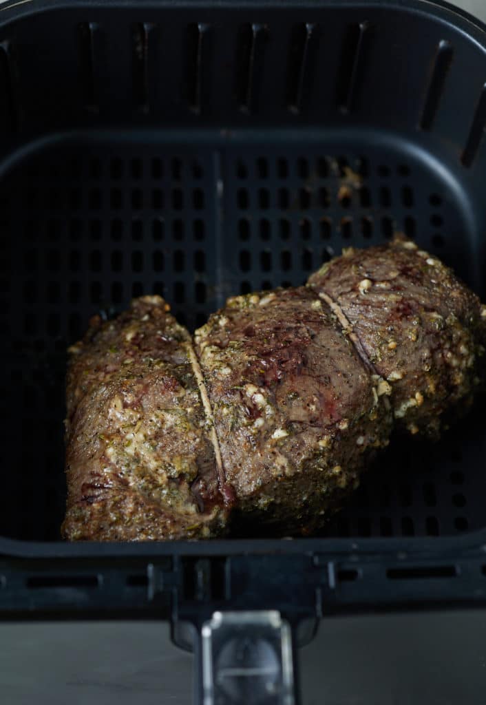 The cooked beef tenderloin in the air fryer basket.