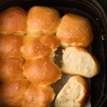 Dinner rolls pulled apart in the air fryer basket.