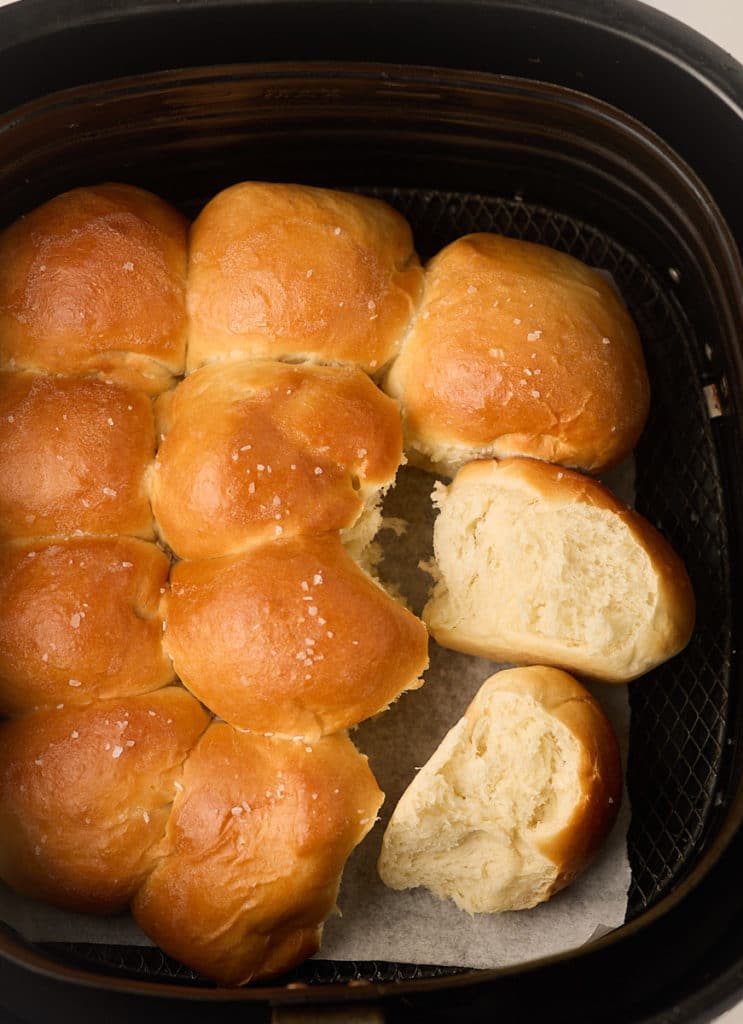 Dinner rolls pulled apart in the air fryer basket.