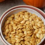 pumpkin seeds with pumpkin in background
