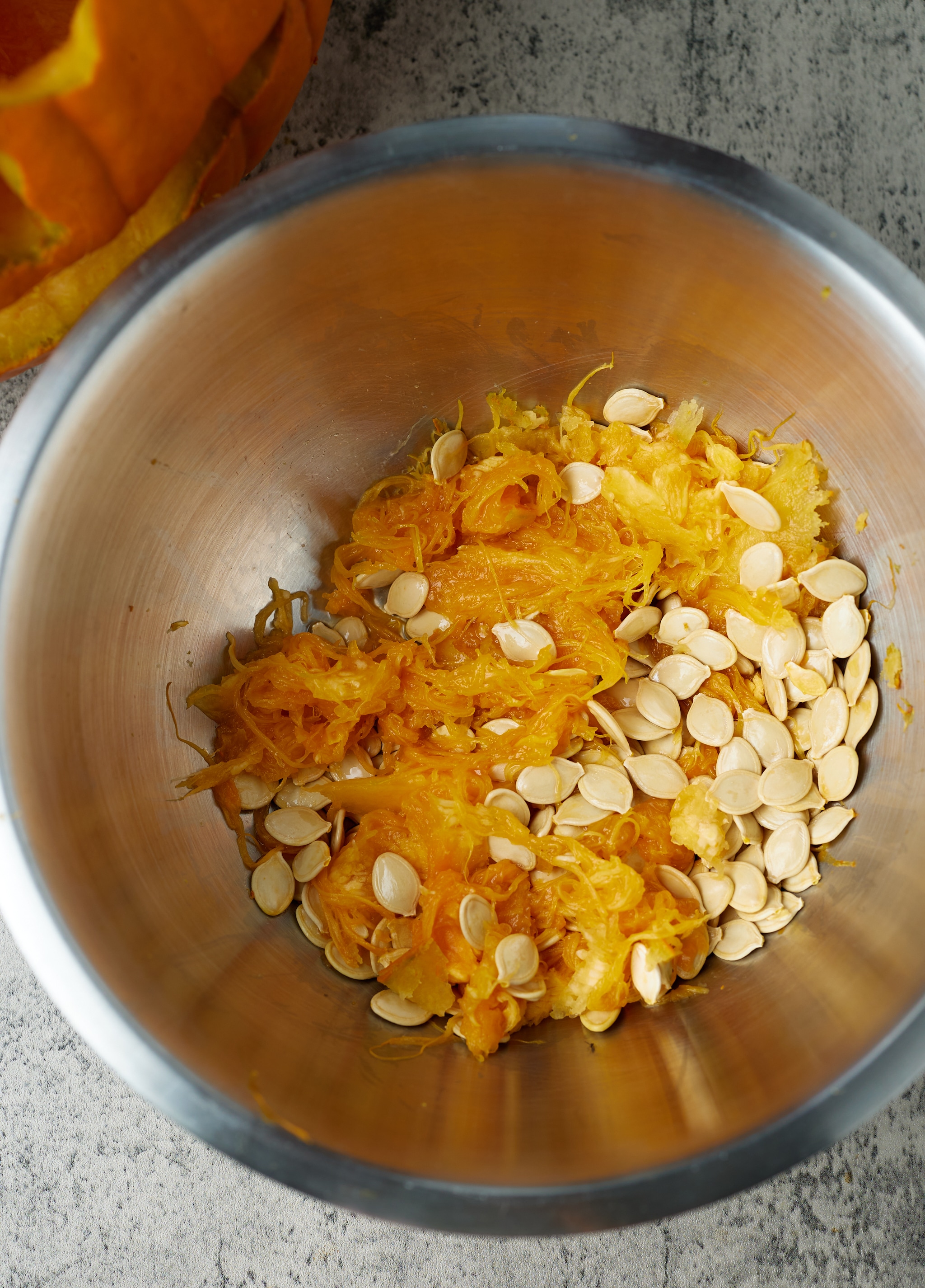 pumpkin seeds and pulp on silver bowl