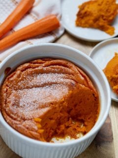 Carrot souffle in a white dish served on to two plates.
