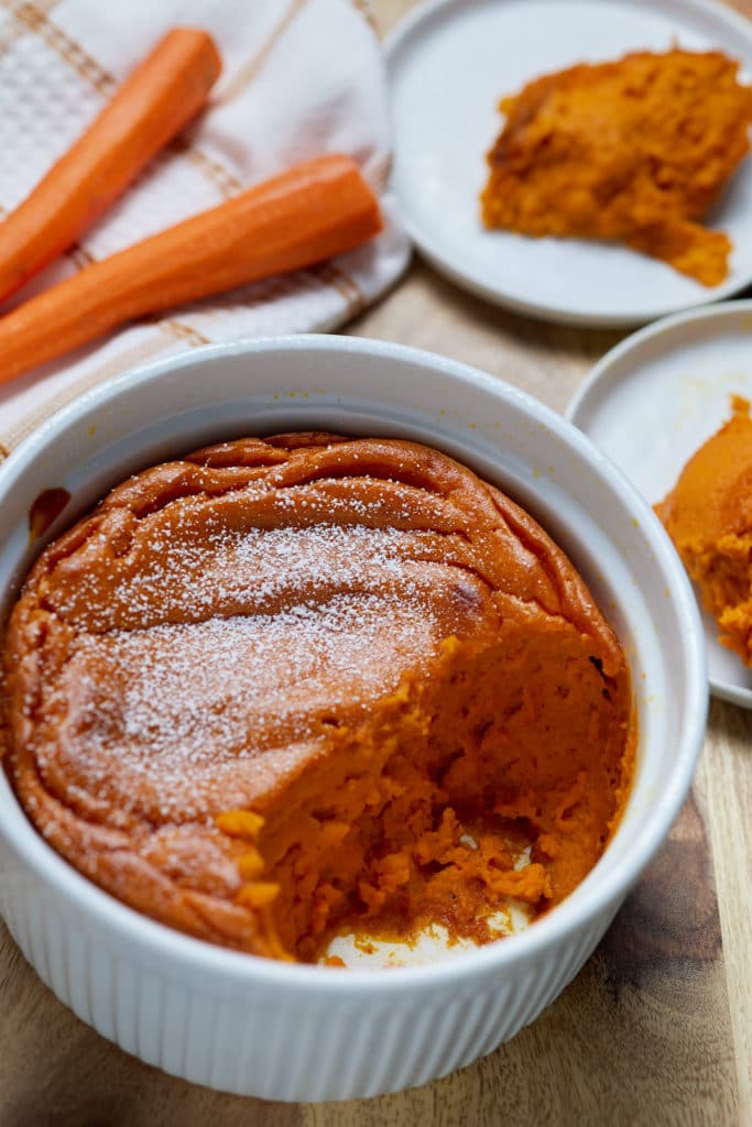 Carrot souffle in a white dish served on to two plates.