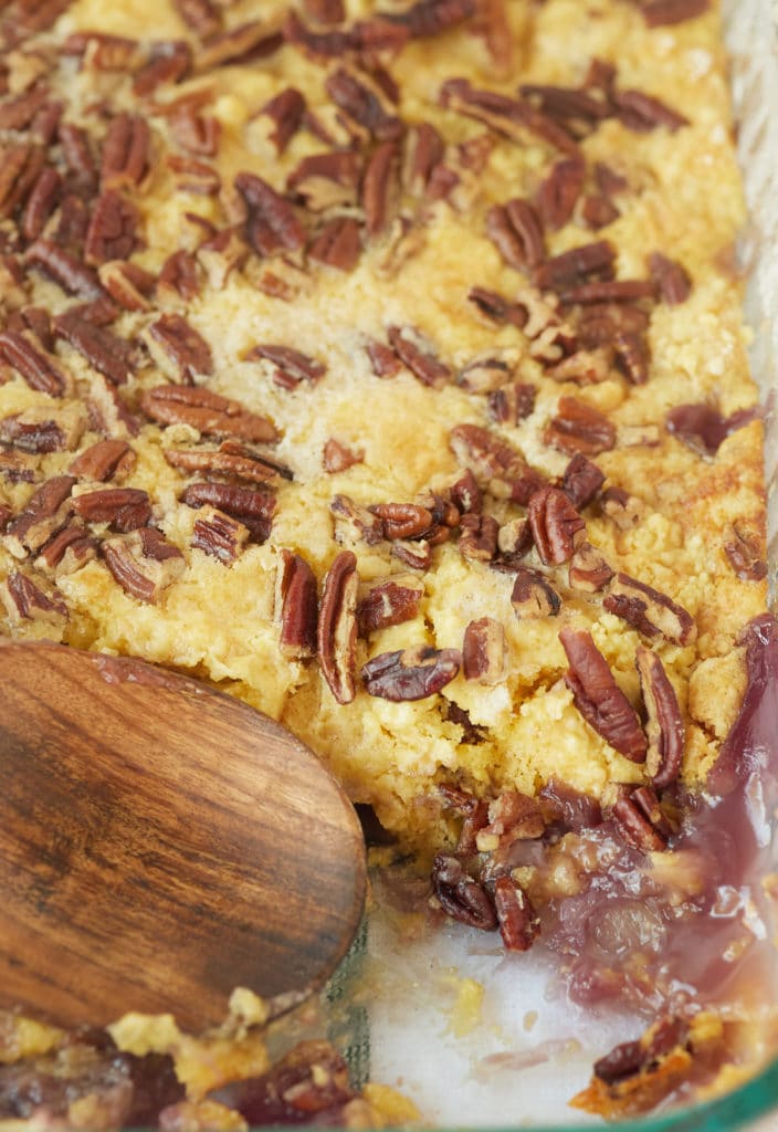 The baked cake in a glass dish with a wooden spoon.