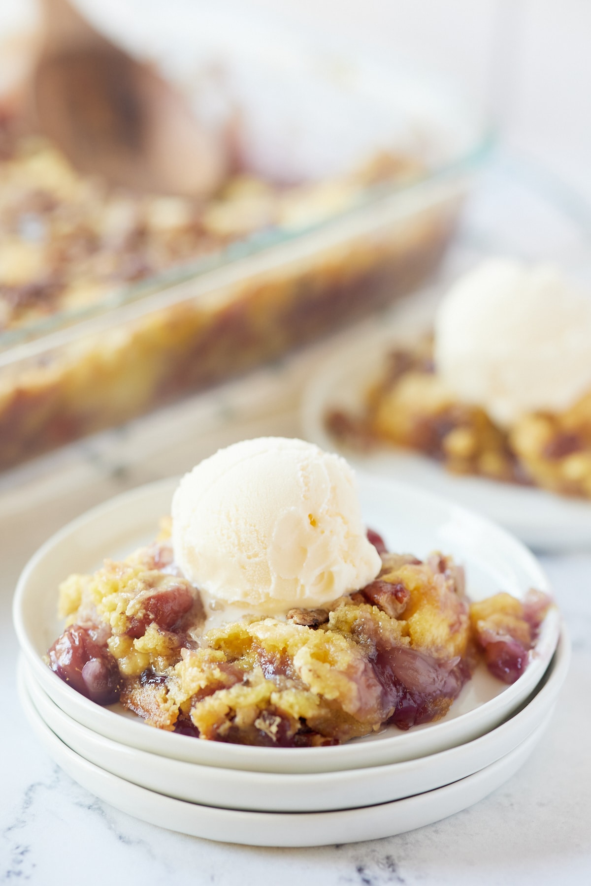Cherry pineapple dump cake served on a plate with ice cream.