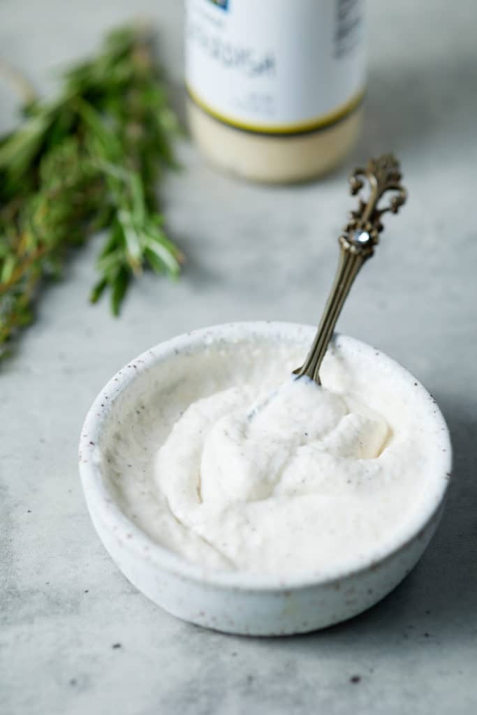 Homemade horseradish sauce in a white bowl with a spoon.