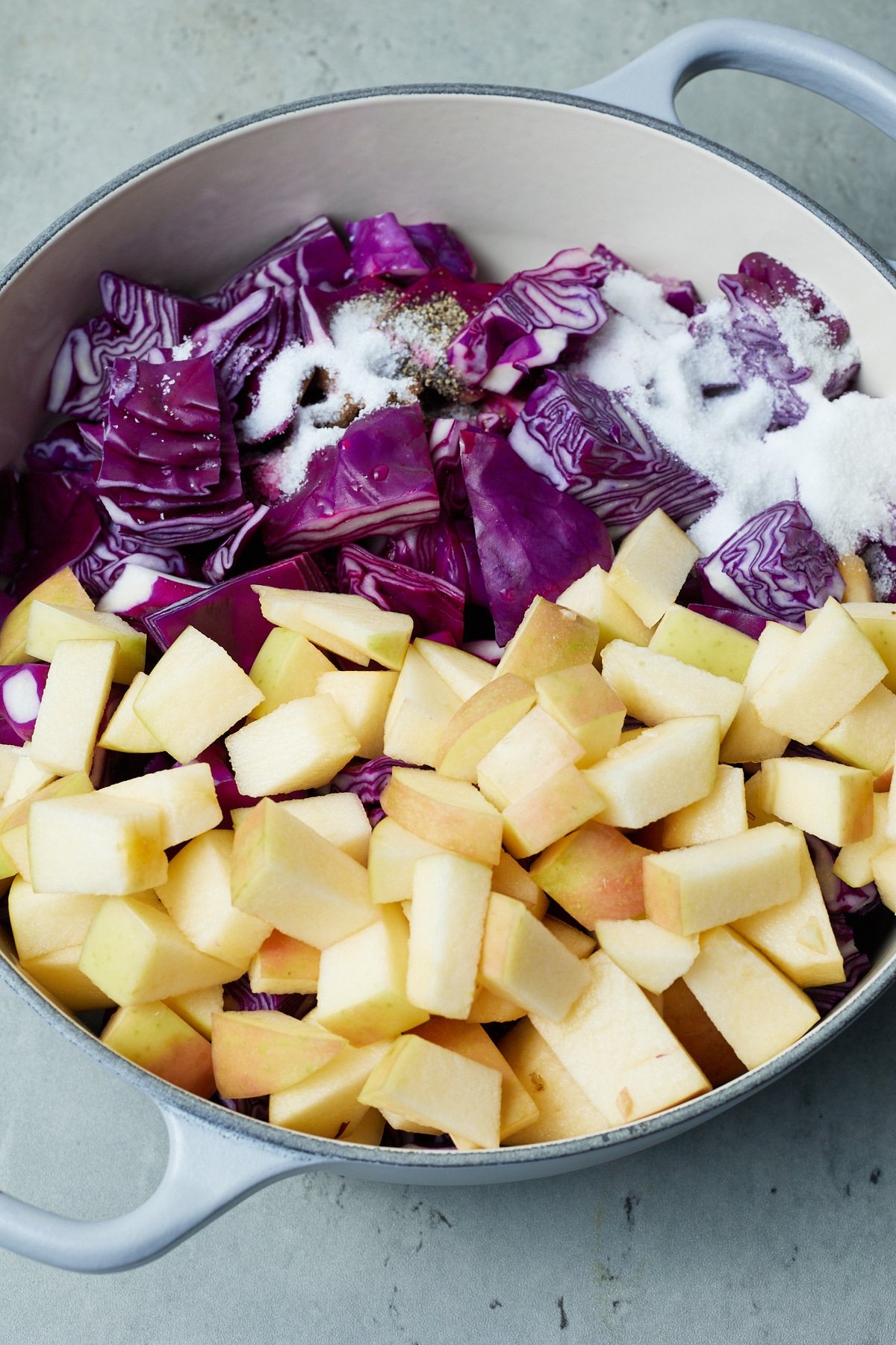 cabbage, apples, salt, and pepper inside pot