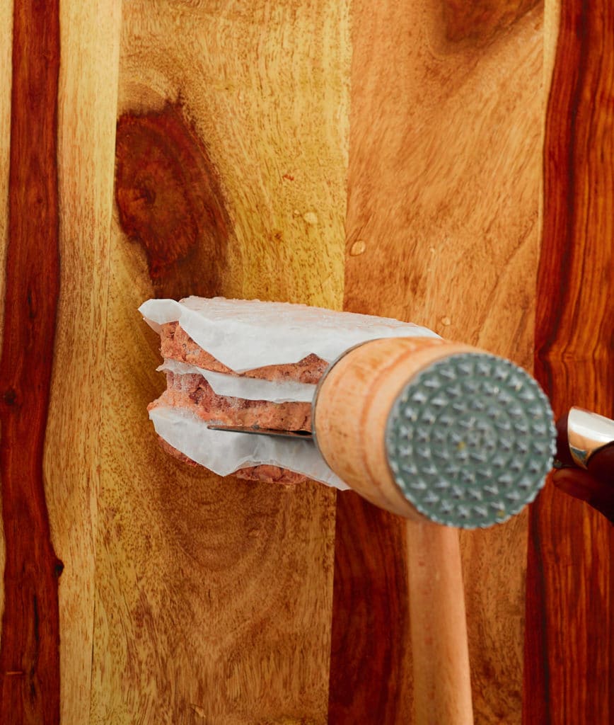 Hitting frozen burgers with a mallet.